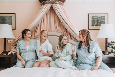 Bride and bridesmaid laughing getting ready at Brocket Hall