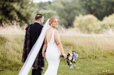 Bride looking back smiling at Brocket Hall, Welwyn